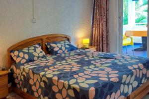 1 dormitorio con 1 cama con edredón azul y amarillo en Villacool - Lot No 25 Residence Le Tamier, en Flic en Flac