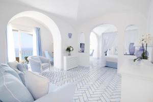 a white room with white furniture and a room with a bed at Hotel Marincanto in Positano
