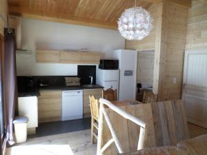 a kitchen and dining room with a table and a chandelier at Gte T3 Le Balarino - Mercantour1 in Belvédère