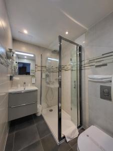 y baño con ducha, aseo y lavamanos. en Kyriad Saint Quentin en Yvelines - Montigny en Montigny-le-Bretonneux