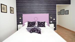 Bella Sorrento B&B في سورينتو: غرفة نوم مع سرير أبيض كبير مع اللوح الأمامي وردي