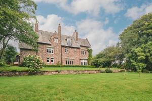 an old brick house with a large grass yard at The Old Vicarage in Holmrook