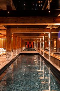 a swimming pool with a m sign in a building at M Lodge & Spa in Saint-Martin-de-Belleville