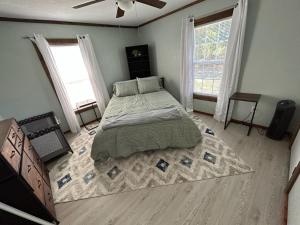 um quarto com uma cama grande e 2 janelas em Lake Fork Fishing Getaway em Quitman