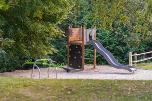 a playground with a slide in a park at Hotel Kardosfa in Zselickisfalud