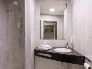 een badkamer met een wastafel en een spiegel bij B&B Hotel Schweinfurt-Süd in Schweinfurt