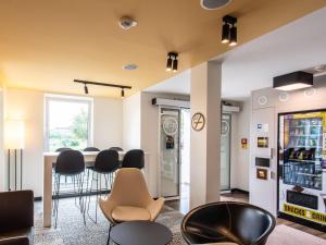 a room with a bar with chairs and a drink cooler at B&B Hotel Schweinfurt-Süd in Schweinfurt