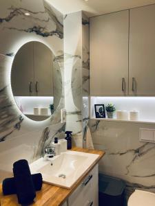 a bathroom with a sink and a mirror at Apartament lovely space in Rzeszów