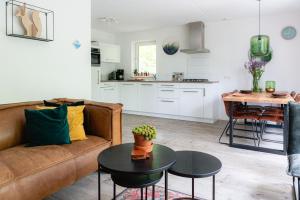 een woonkamer met een bank en een tafel bij Luxe Vakantiehuis Grove Den Veluwe in Nunspeet