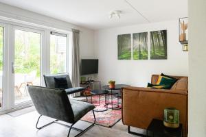 a living room with a couch and a chair at Luxe Vakantiehuis Grove Den Veluwe in Nunspeet
