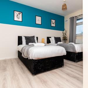 2 Betten in einem Zimmer mit blauen Wänden in der Unterkunft Fife - Driveway Parking Spacious 4 bed house Sleeps 6 Ideal Contractor Accommodation in Gateshead