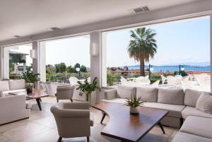 a living room with white furniture and large windows at Alexandros Palace in Ouranoupoli