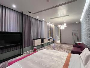 a bedroom with a large bed and a flat screen tv at Moonlight Motel in Taichung