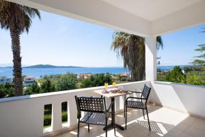 a balcony with a table and chairs and a view of the ocean at Alexandros Palace in Ouranoupoli +209 photos