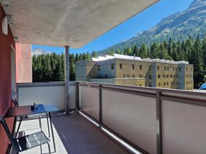 a balcony with a table and a view of a building at Apartment Via Surpunt - Bella - 3 Rooms in St. Moritz