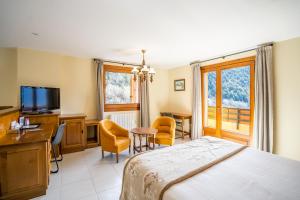 - une chambre avec un lit, un bureau et une télévision dans l'établissement Abba Ordino Babot Hotel, à Ordino