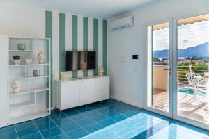sala de estar con TV y balcón en Magarella, en Villammare