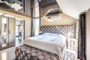a bedroom with a large bed with a large window at LA VILLA DE SENY , villa de charme avec jardin ,Piscine nature, jacuzzi , petanque, fitness, billard,ping pong, in Seny +60 photos