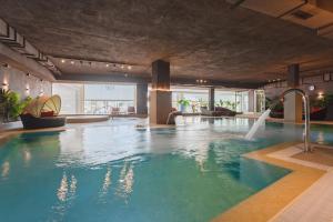 a large pool with a water slide in a building at Hotel Cleopatra Palace in Playa de las Americas