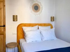 uma cama com almofadas brancas e um espelho na parede em Andalusian house - Beach at 85 meters - Terrace em Málaga