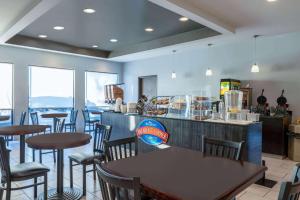 a restaurant with tables and chairs and a counter at Baymont by Wyndham Rapid City in Rapid City