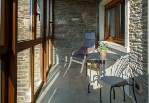 a patio with a table and two chairs and a window at Casa Baran in Sarria