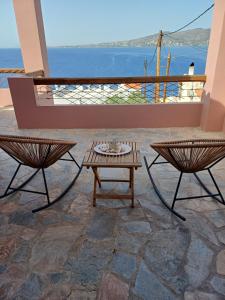 a patio with a table and two chairs at Calma in Perdika