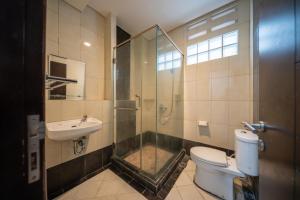 a bathroom with a shower and a toilet and a sink at Cove Sky City Home in Bandung