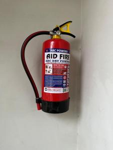 a fire extinguisher hanging on a wall at Vedika Yatri Grah - Entire Apartment in Ujjain