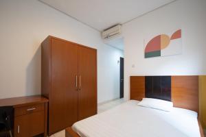 um quarto com uma cama e um armário de madeira em Cove Sky City Home em Bandung