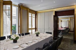 Park Hyatt Paris - Vendôme في باريس: قاعة المؤتمرات مع طاولة وكراسي طويلة