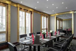 a row of tables in a room with windows at Park Hyatt Paris - Vendôme in Paris