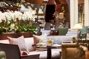 a restaurant with couches and tables and flowers at Park Hyatt Paris - Vendôme in Paris