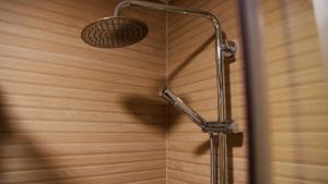 una ducha con cabezal de ducha en una pared de madera en HOTEL LOS ALAMOS BOUTIQUE, en Plasencia