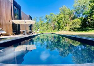 a swimming pool with blue water in front of a building at Villa Le Touquet, piscine privée, 4 chambres in Le Touquet-Paris-Plage