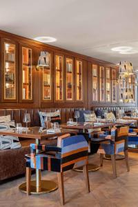 Wine & Books Porto Hotel في بورتو: مطعم بطاولات خشبية وكراسي زرقاء