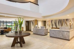 a lobby with a waiting area with a table at Hilton Garden Inn Monterey in Monterey
