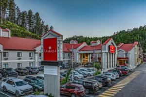 un groupe de voitures garées sur un parking d'un hôtel dans l'établissement Ramada by Wyndham Keystone Near Mt Rushmore, à Keystone