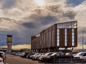 um edifício com muitos carros estacionados num parque de estacionamento em Novotel Christchurch Airport em Christchurch