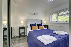a bedroom with a blue bed with towels on it at The Braybrooke Executive House with Parking & Garden "Green Tourism Award" By SILVA in Loughton