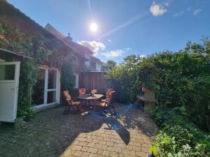 un patio con mesa y sillas en un patio trasero en Alpaka Ferienhof Lübsee, 