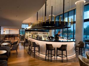 Un uomo in piedi in un bar in un ristorante di Pullman Brisbane Airport a Brisbane