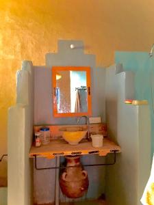 een badkamer met een wastafel en een spiegel bij Dar Oasis Moringa in Merzane