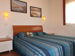 1 dormitorio con 1 cama grande con manta azul en Modern flat in a fantastic residence with pool, en Bibione
