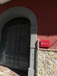 a black door with a red sign in front of a building at B&B Dei Vicari in Frattamaggiore