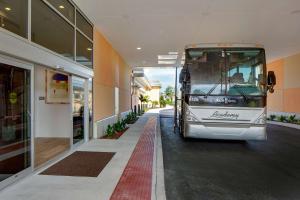 Hay un autobús estacionado al lado de un edificio. en Hyatt House across from Universal Orlando Resort en Orlando