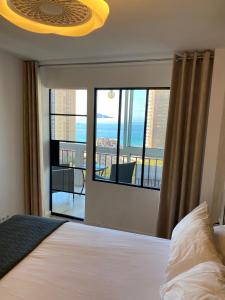 um quarto com uma cama e uma grande janela em Apartamento BENILOVE, en playa Benidorm em Benidorm