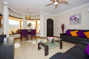 a living room with a couch and a table at Riviera Park 2b, central 2 bed in Puerto del Carmen