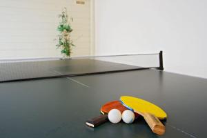 a ping pong racket and three balls on a table at Riviera Park 2b, central 2 bed in Puerto del Carmen