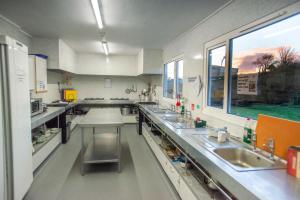 a large kitchen with sinks and a large window at Broadford Youth Hostel in Broadford